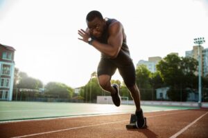 Runner taking off from blocks on track.
